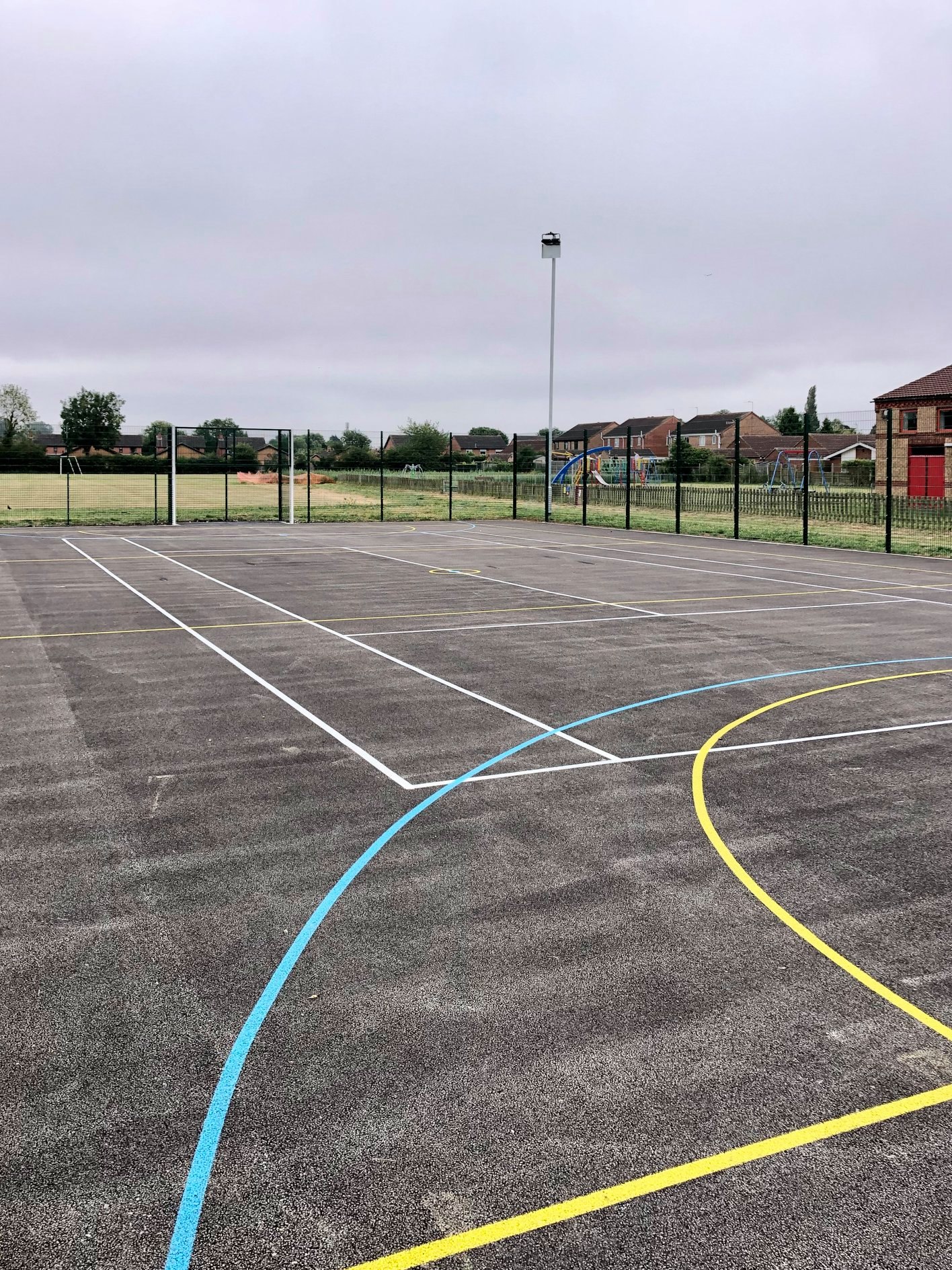 A multi use games area  featuring clearly marked yellow lines, ready for a match or practice session.