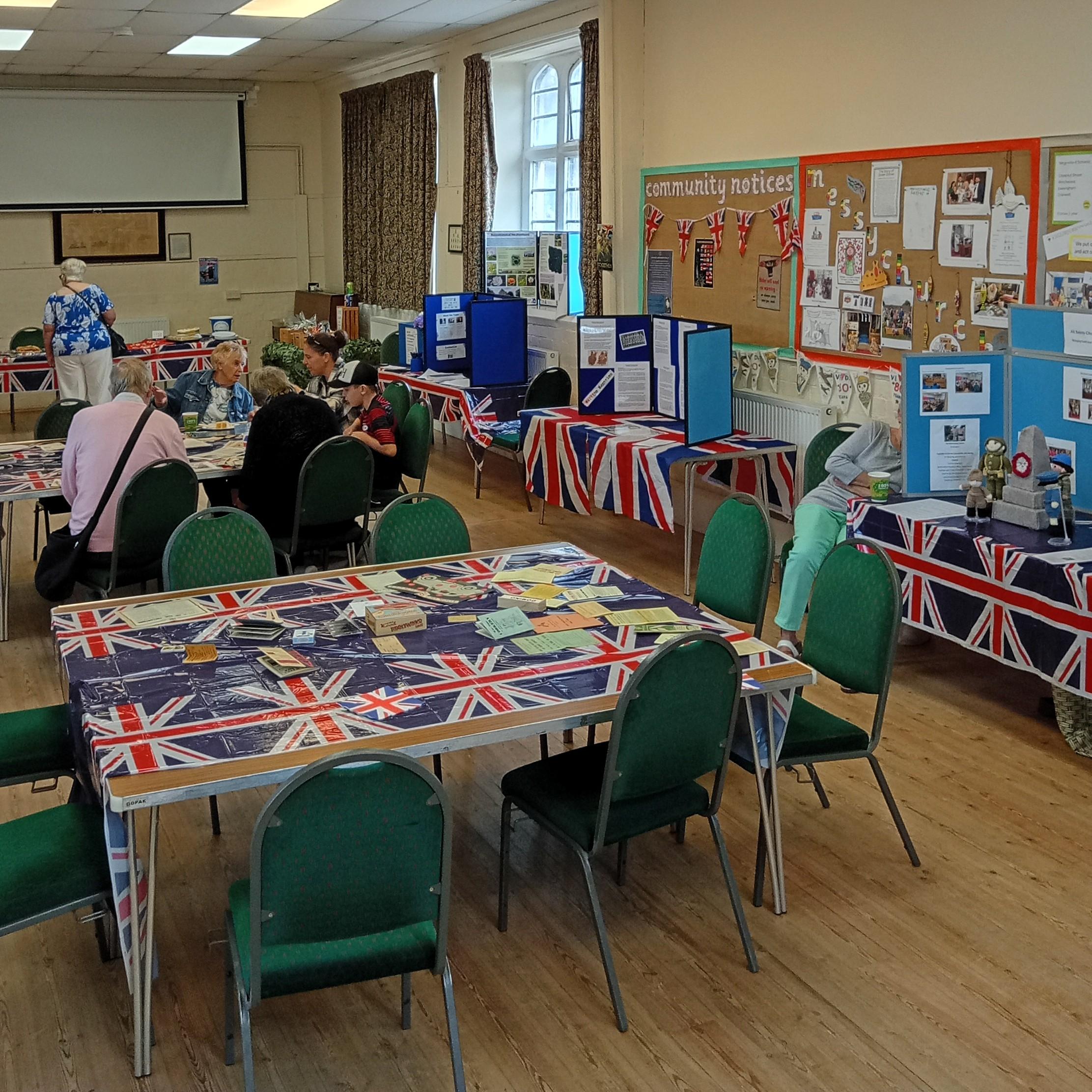 A room filled with tables and chairs, all adorned with vibrant British flags for a festive atmosphere.
