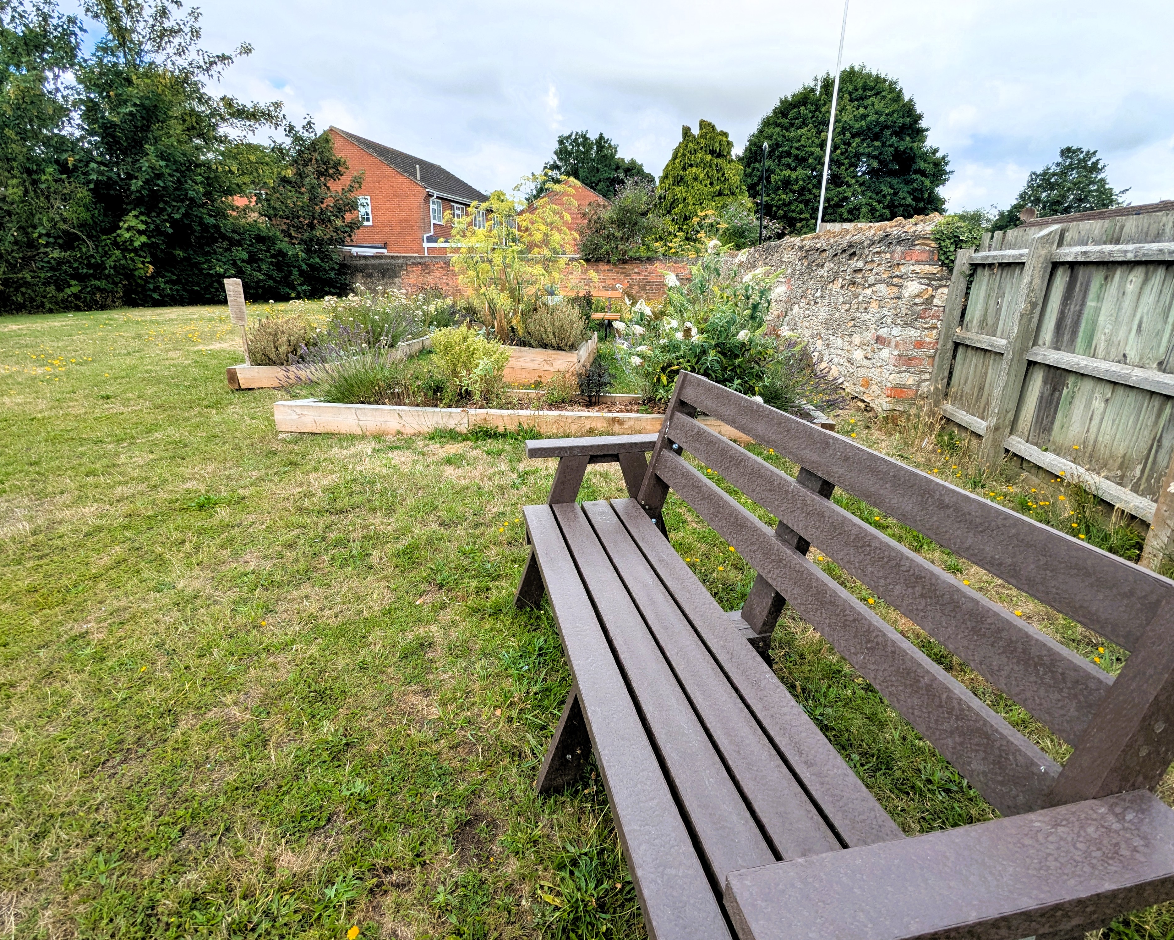 A wooden bench placed in a lush grassy area, inviting relaxation in a natural setting.