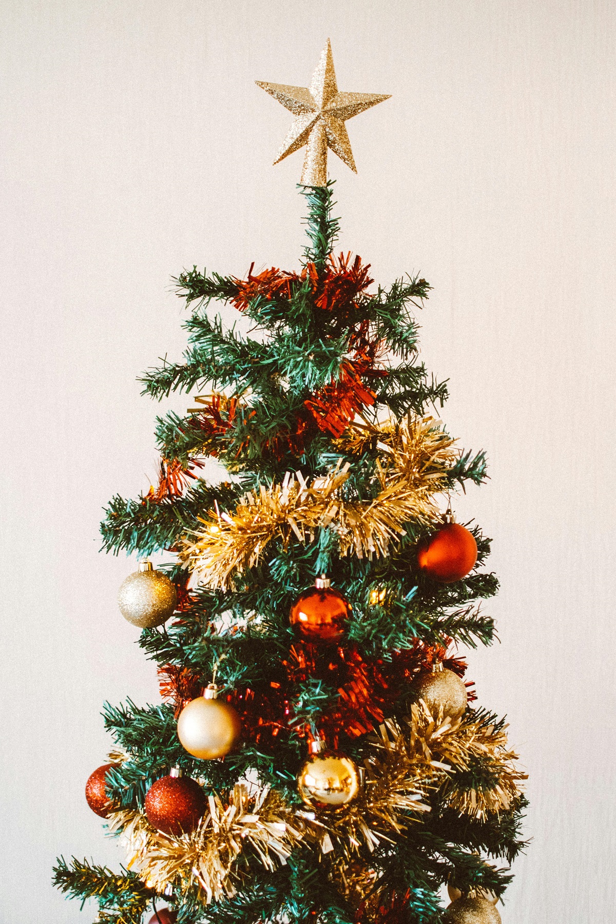 A photo of a christmas tree decorated with tinsel and baubles