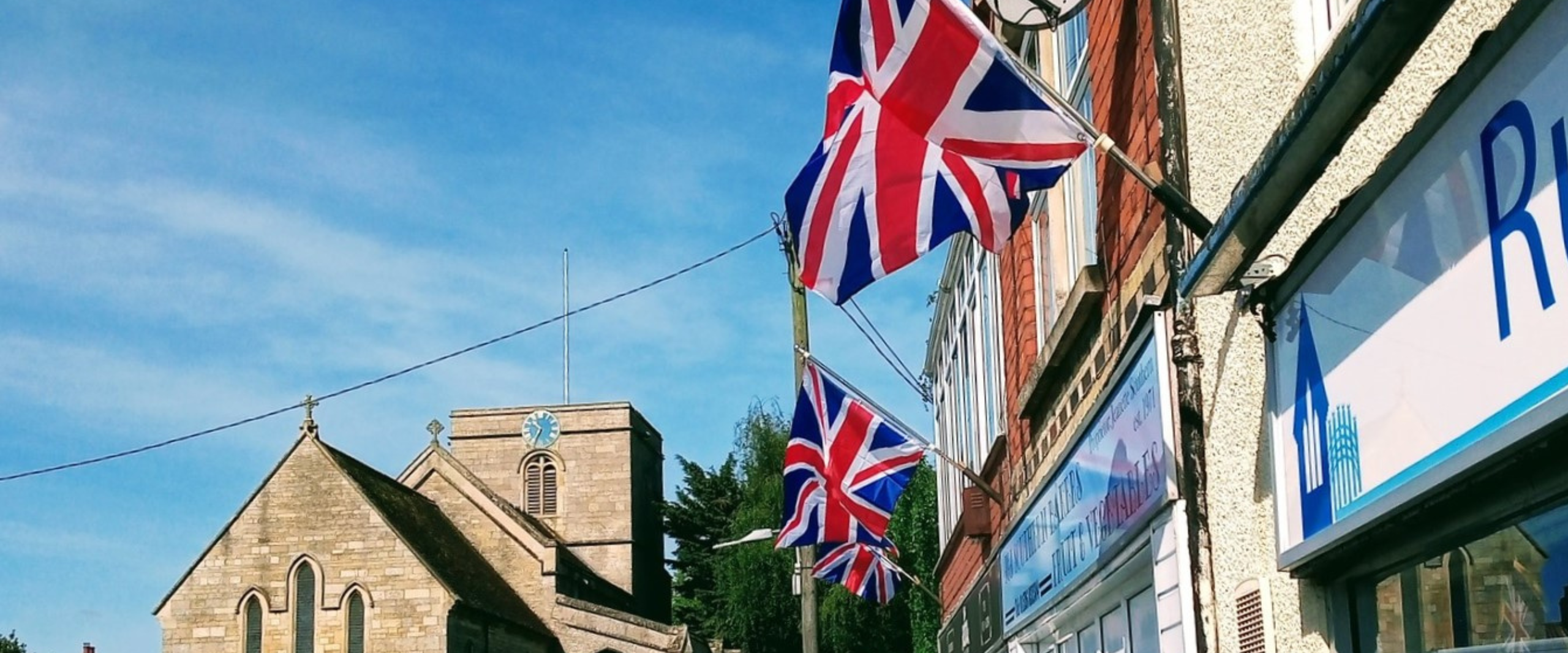 A picturesque street lined with a church and Union Jack flags, symbolizing a vibrant community and cultural heritage